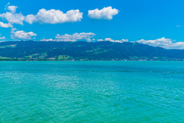 Fototapeta na wymiar Germany, Beautiful panorama view above lakeside of turquoise bodensee lake water at austria coast and bregenz city, pfaender mountain