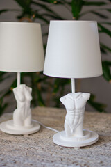 white lamps with male and female torsos made of gypas white in the interior