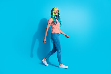 Full size profile side photo of young lady with eccentric aquamarine hair go shopping isolated on blue color background