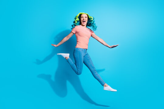 Full body image of energetic good mood lady jumping up enjoy warm summer weather go on walk isolated on blue color background