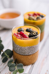 Healthy vegan chia pudding with mango sauce and fresh berries
