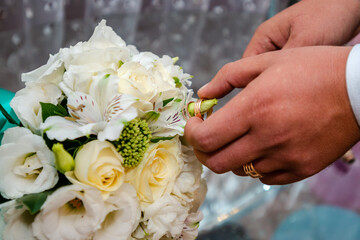 The groom holds a wedding bouquet. Wedding day
