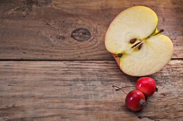 Whole apples and half on a wooden table