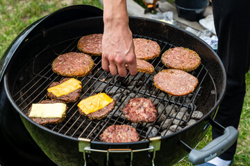 Selective focus of fresh delicious burger cutlets with cheese grilling on bbq grill