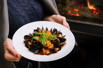 Delicious fresh steamed mussels in white wine sauce in a white plate