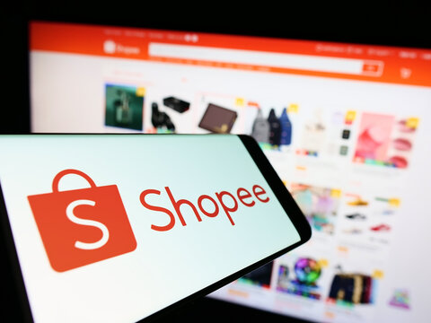 Stuttgart, Germany - 09-10-2022: Cellphone with logo of Singaporean e-commerce company Shopee on screen in front of business website. Focus on center-right of phone display.