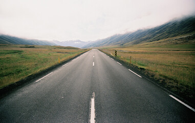 Asphalt road with mountain view in Iceland. Grainy film in the style of old photos. High quality photo