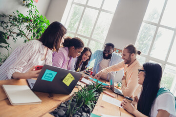 Photo of funny friendly businesspeople chatting gadgets talking about startup indoors workstation workshop restroom