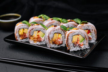 Eel sushi rolls on black plate