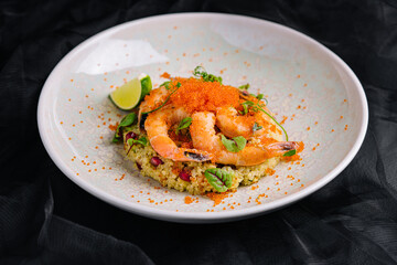 Couscous with vegetables and shrimp under red caviar
