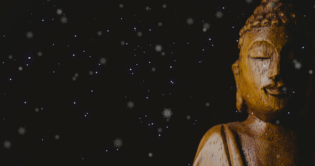 Obraz premium Image of snow falling over buddha on black background