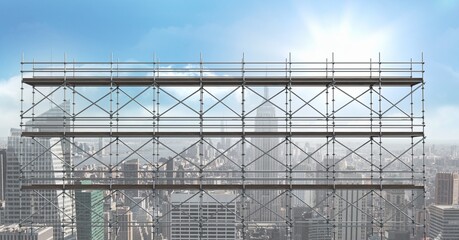 Construction scaffolding over a cityscape against clouds in the blue sky with copy space