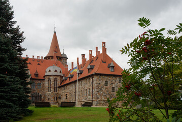 Fototapeta na wymiar .a beautiful castle wall with a flying flag and an orange-red roof on a cloudy autumn day