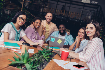 Photo of funny positive businesspeople embracing having meeting indoors workstation workshop restroom