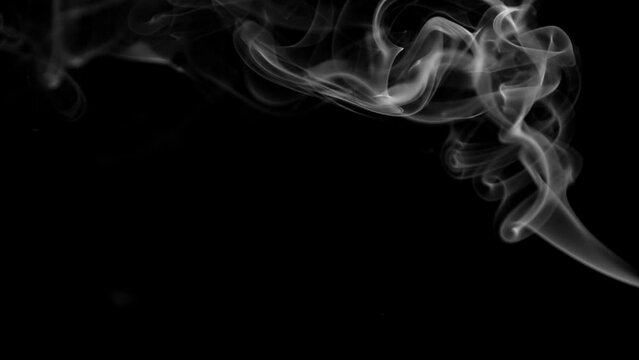 Stream of wispy smoke over a black background. Vertically Orientated Video.
