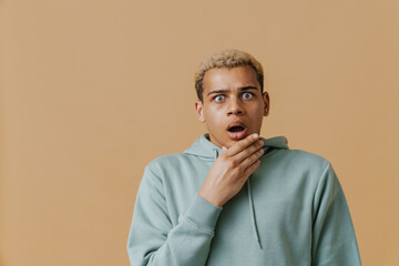 Blonde young man wearing hoodie expressing surprise at camera