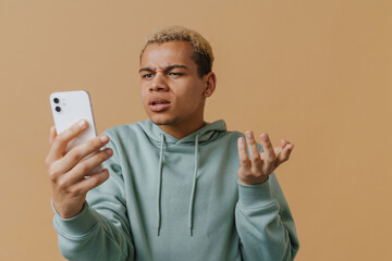 Blonde young man gesturing and talking on cellphone