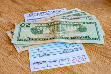 Money and a check on a table at a small diner in Upstate NY. Cash is used to pay bill.