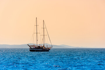 Fototapeta na wymiar Lonely sailboat sails on the sea at dawn, beautiful landscape