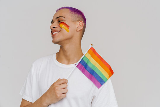 Portrait of young handsome smiling happy boy holding LGBT flag