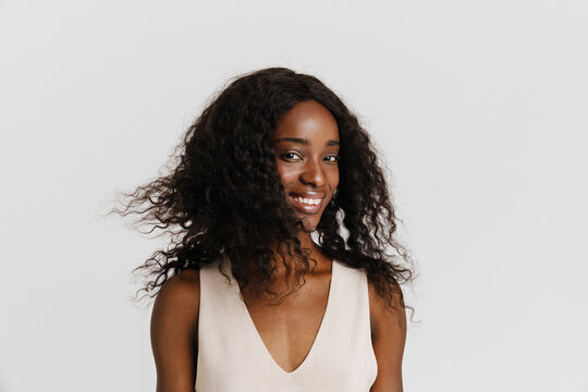 Young beautiful attractive long-haired smiling african woman looking at camera