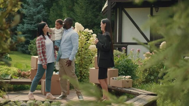 Asian female real estate agent selling a house to a multi-ethnic family. African dad, Caucasian mom, child.Multiracial Family,Mixed Race,Diverse People,Multiethnic Relations