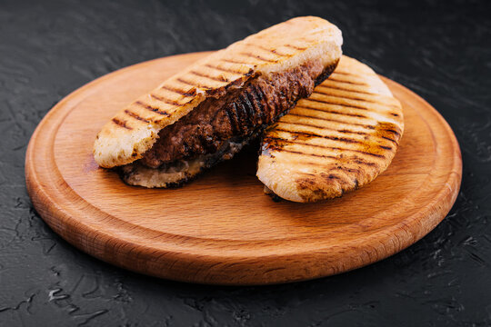fried pita with pork steak on wooden tray