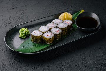 Sushi roll set in a plate on black plate