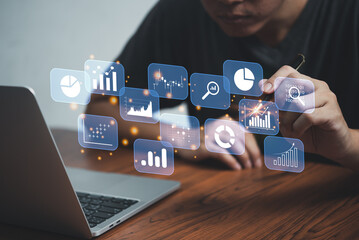 Big data analytics BI intelligence business concept with chart and graph icons on interface and businessman holding pen touching virtual screen.