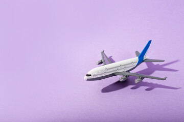 Top view of white model plane, airplane toy on isolated purple background. Flat lay with copy...