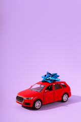 Red children's toy car model preset and surprise isolated on purple background. close up and copyspace