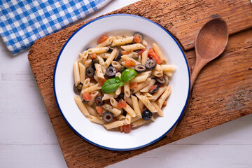 Sicilian pasta with olives, tomato and olive oil. Traditional recipe from the island of Sicily.