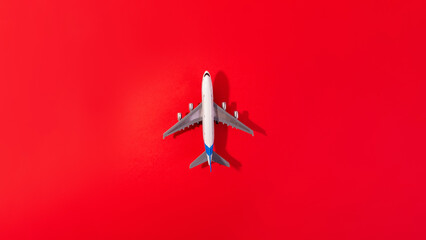 Top view of white model plane, airplane toy on isolated red background. Flat lay with copy space....