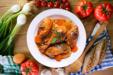 Chicken with vegetable sauce, carrots, peas and potato. Traditional Spanish dish recipe.