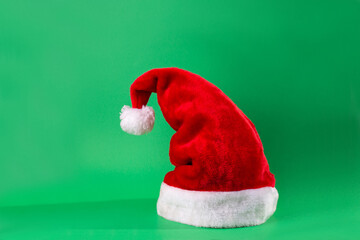 Santa Claus red hat isolated on green background. Happy new year concept, flatlay, copyspace.