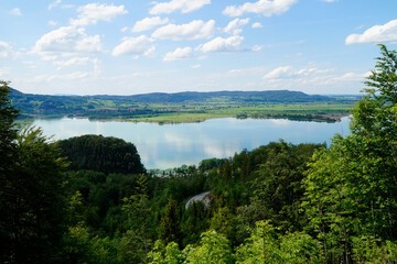 Fototapeta na wymiar lake Kochel or Kochelsee in the scenic Bavarian Alps surrounded by the lush green trees on a sunny day in May (Bavaria, Germany)