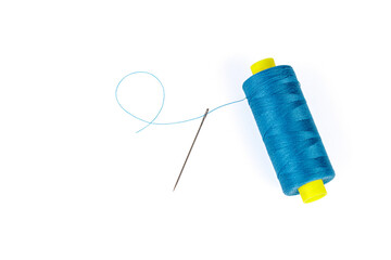 Macro skein of blue thread with a needle on a white background