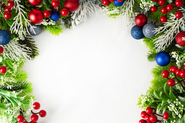 Naklejka na ściany i meble Fir branches and Christmas decor in red and blue colors on a white background with space for writing text.