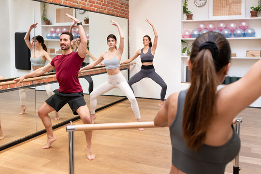 Group of people doing plie on barre