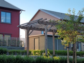 Roof of beams in a wooden gazebo under a canopy in a middle of modern scandinavian