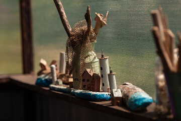 Wooden island with a driftwood lighthouse, driftwood, stand on the window. handmade