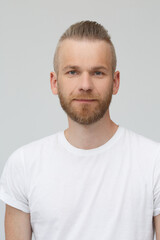 Portrait of handsome bearded man in white t-shirt isolated on gray background.