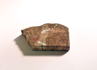 A piece of wood with a few colors on a white studio background
