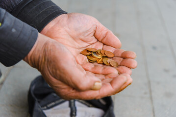 Poor Beggar hands with euro coins begging for money.outdoors, closeup.