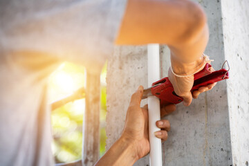 Construction worker holding tools to install cable duct system inside building
