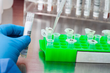 Closeup of a scientist extracting DNA using the spin column-based nucleic acid purification technique. Spin column-based nucleic acid purification technique. Diagnosis of human papillomavirus virus. - obrazy, fototapety, plakaty