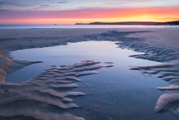 Tidal pools on a deserted sandy beach at sunrise, Harlyn Bay, Cornwall, England