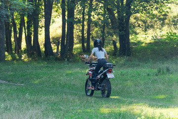 Fototapeta na wymiar Young woman driving motorcycle. Confident biker girl moving on motorbike on country road. Sport racer loves speed driving. Concept drive and free.