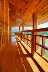 Vertical photo of beautiful wooden building corridors japan style and natural scenery in the background.