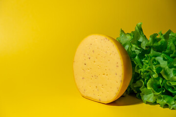 a large piece of cheese with walnuts on a yellow background